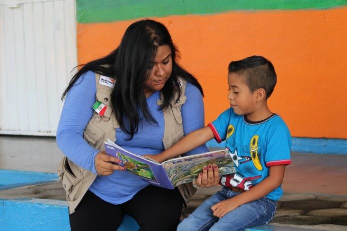mujer enseñando un libro a un niño