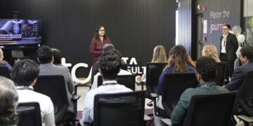 Especialista en tecnología de TCS mostrando el panel de control de la plataforma cloud para la gestión de pacientes con cáncer.